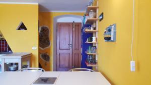a kitchen with yellow walls and a wooden door at Ca' Tinetto in Fezzano
