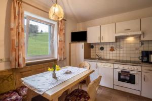 a kitchen with a table and a window at Ferienwohnung Kirchblick Gasser in Terento