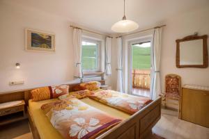 Un dormitorio con una cama grande y una ventana en Ferienwohnung Kirchblick Gasser, en Terento