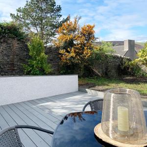 une table et des chaises sur une terrasse en bois dans l'établissement Orkney Staycations - Thorvald, à Finstown