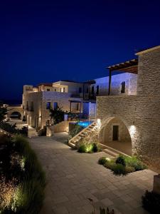 a stone building with a staircase leading up to it at night at Margo Beach Hotel in Gythio