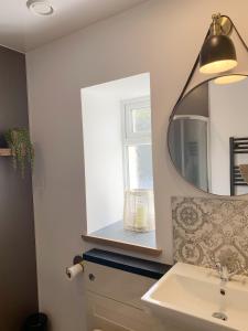 a bathroom with a sink and a mirror at Orkney Staycations - Thorvald in Finstown