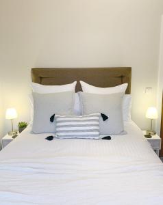 duże białe łóżko z białymi poduszkami i 2 lampami w obiekcie Orkney Staycations - Thorvald w mieście Finstown