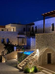 uma villa com piscina à noite em Margo Beach Hotel em Gythio