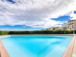 a large blue swimming pool next to a building at CORTADERIA B002 in Saint-Cyprien