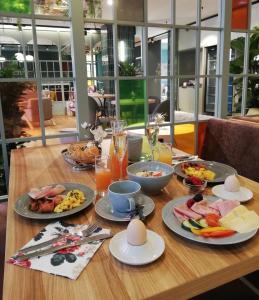 una mesa de madera con platos de comida. en Stadtoase Kolping Hotel en Linz