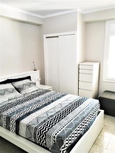 een slaapkamer met een bed met een zwart-wit dekbed bij Apartament a la Costa Brava l'Estartit - MyAnna in L'Estartit