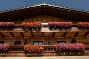 un bâtiment avec des fleurs roses sur les balcons dans l'établissement Gasthof Steinerwirt, à Großgmain