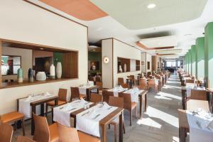 a dining room with tables and chairs in a restaurant at Hotel Riu Costa del Sol - All Inclusive in Torremolinos