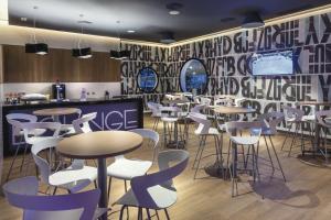 a dining room with tables and chairs and a wall with a mural at Hotel Riu Costa del Sol - All Inclusive in Torremolinos