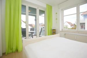 a bedroom with a white bed and green curtains at Dünenblick Wohnung 07 in Boltenhagen