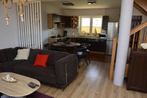 a living room with a couch and a kitchen at Apartament z widokiem na morze "U Grażyny" in Jarosławiec