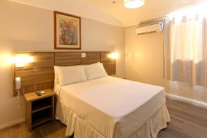 Un pat sau paturi într-o cameră la Fênix Hotel Moema