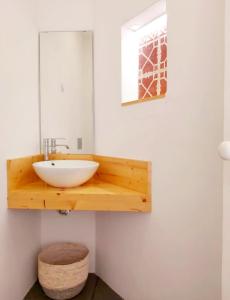 baño con lavabo y espejo en la pared en Casa do Arco by HnM, en Tavira