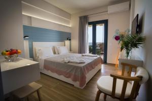 a hotel room with a bed and a table and a chair at Eleni Studios Parga in Parga