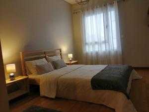 - une chambre avec un grand lit et une fenêtre dans l'établissement AzorRelax City, à Ponta Delgada