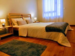 a bedroom with a large bed and a rug at AzorRelax City in Ponta Delgada