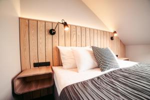 Schlafzimmer mit einem großen Bett mit einem Kopfteil aus Holz in der Unterkunft Usma SPA Hotel & Camping in Usma
