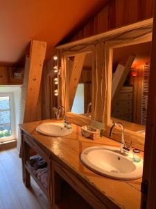 ein Badezimmer mit zwei Waschbecken und einem großen Spiegel in der Unterkunft Le Potala in Le Bouchet-Saint-Nicolas