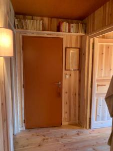 eine Tür in einem Zimmer mit Holzwänden und Holzböden in der Unterkunft Le Potala in Le Bouchet-Saint-Nicolas