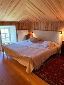 ein großes Bett in einem Zimmer mit Holzdecke in der Unterkunft Le Potala in Le Bouchet-Saint-Nicolas
