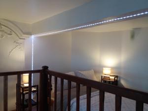Cette chambre dispose d'un lit et d'un escalier avec des lumières. dans l'établissement Studio la Nuit au Coeur de ville, à Limoux