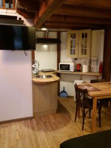 una cucina con un lavello e un tavolo con sedie di Studio la Nuit au Coeur de ville a Limoux Altre 27 foto