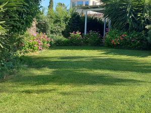 podwórko z trawnikiem z kwiatami i domem w obiekcie CORAL BAY suite Cyprus w mieście Coral Bay