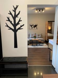 un salon avec un arbre au pochoir sur le mur dans l'établissement Donau Apartment Vienna, à Vienne