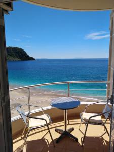 balcón con mesa, sillas y vistas al océano en Magic Ionian Apartments & Rooms, en Himare