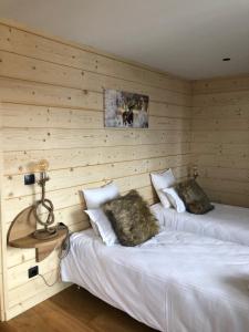 two beds in a room with wooden walls at Chalet Hibou in Les Deux Alpes