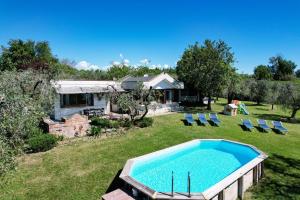- une piscine dans une cour avec des chaises et une maison dans l'établissement Casa Raffaella -Ciao Vacanze-, à Moniga del Garda