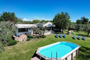 a swimming pool in a yard with chairs and a house at Casa Raffaella -Ciao Vacanze- in Moniga