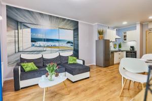 a living room with a couch and a table at Apartament Cesarski in Świnoujście