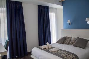 1 dormitorio con 1 cama con paredes azules y cortinas azules en Palazzo Cappuccini Art Relais en Nápoles