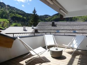 two chairs on a deck with a view of a mountain at BOREAL Bel appartement village et pistes in La Clusaz