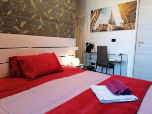 Un dormitorio con una cama roja con toallas. en B&B IL SOGNO en Turín