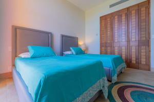 2 camas en una habitación con sábanas azules en Isla Sunset Rentals at Sotavento en Isla Mujeres
