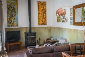 a living room with a couch and a stove at Les Cases de Cal Pastor in Vilert