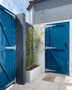 eine blaue Garagentür auf einem Haus mit einer Pflanze in der Unterkunft Jays Bay Entire Luxury Apartment by the Beach Gt Yarmouth in Great Yarmouth