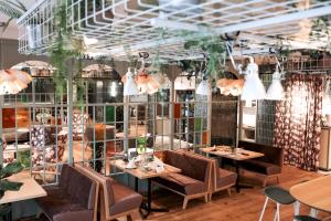 a restaurant with tables and chairs and lights at Stadtoase Kolping Hotel in Linz