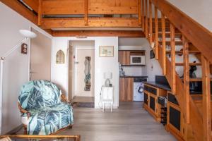 a living room with a staircase and a couch at Emplacement idéal - Trou du Diable sur la Corniche in Les Bussolleries