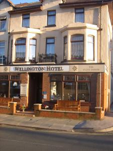 a building with benches in front of a wharton hotel at Wellington Hotel in Blackpool
