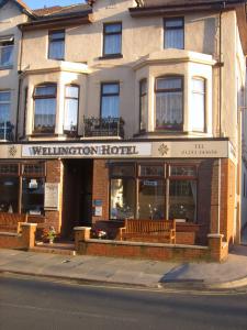 un edificio con bancos frente a un hotel wharton en Wellington Hotel, en Blackpool