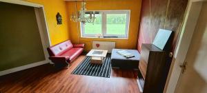 a living room with a red couch and a table at Luna Solis Stay Zimmer und Hostel nahe A1 in Heidenau
