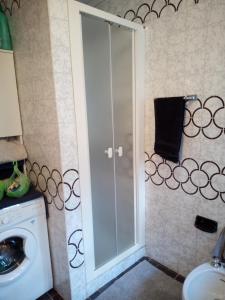 een badkamer met een wasmachine en een glazen deur bij Bellagio Bellavista di Betty in Civenna