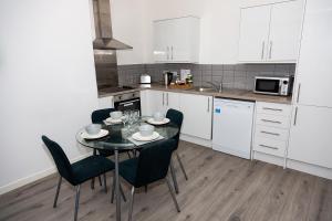 a kitchen with a table and chairs in a kitchen at Alexander Apartments Powdene House in Newcastle upon Tyne