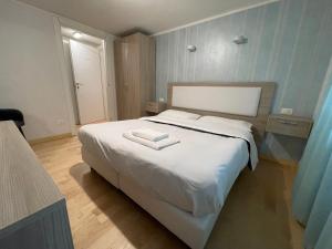 Un dormitorio con una gran cama blanca con un libro. en Laterani Guest House en Roma