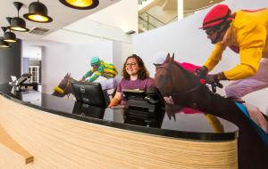 a woman sitting in an office with a horse statue on the desk at ibis Styles Haydock in Haydock