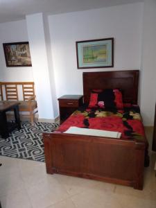 a bedroom with a wooden bed and a table at 1B studio 2beds air conditioned basement114 green beach in El Alamein